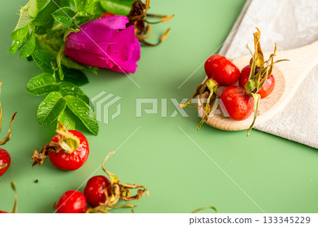 harvest of red rose hips on a green background harvest of red rose hips on a green background 133345229