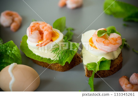 Sandwich with egg and shrimp on gray background from above Sandwich with egg and shrimp on gray background from above 133345261