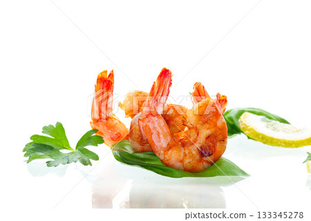 Juicy fried shrimps with lemon wedges isolated on white Juicy fried shrimps with lemon wedges isolated on white 133345278