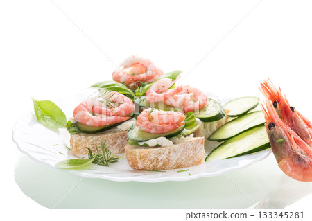 Delicious portioned appetizers with shrimps and greens on a white background 133345281
