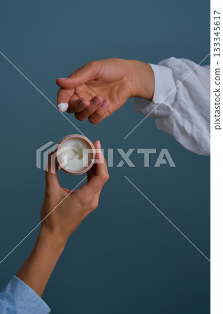 Hands sharing moisturizing cream for skincare routine Hands sharing moisturizing cream for skincare routine 133345617