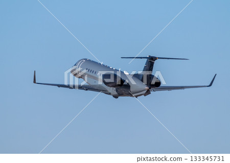 Modern luxury bizjet gains altitude in the blue sky 133345731