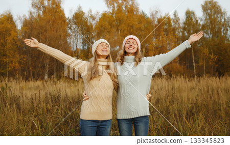 Happy young women friends having fun in autumn park, girlfriends together outdoors Happy young women friends having fun in autumn park, girlfriends together outdoors 133345823