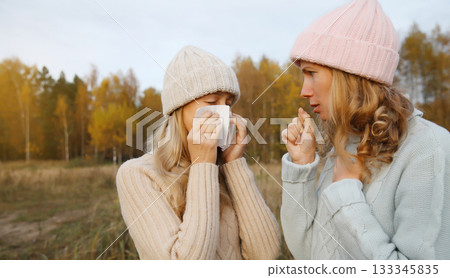 Sick women sneezing blow nose using tissue, unhealthy suffering girls feels unwell outdoors Sick women sneezing blow nose using tissue, unhealthy suffering girls feels unwell outdoors 133345835