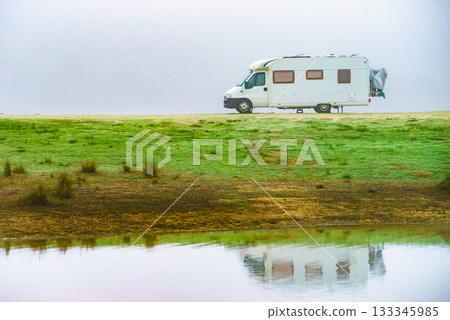 Camper rv camping at lake shore. Foggy day 133345985