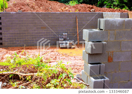 Workers are building masonry block wall on construction site. foundation work in progress. Workers are building masonry block wall on construction site. foundation work in progress. 133346087