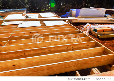 Workers prepare construction site with wooden beams arranged neatly Workers prepare construction site with wooden beams arranged neatly 133346088