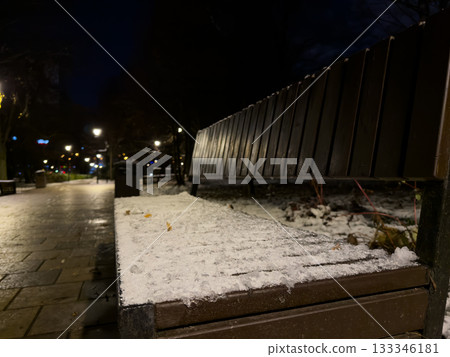 Bench covered in snow and frozen solid. Frozen seat in city park on cold evening. Bad weather with sub zero temperatures. Seat is covered in fresh frozen snow, making it impossible to sit in park Bench covered in snow and frozen solid. Frozen seat in city park on cold evening. Bad weather with sub zero temperatures. Seat is covered in fresh frozen snow, making it impossible to sit in park 133346181