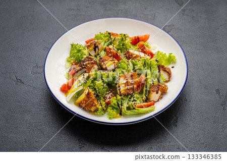 Crispy chicken salad with lettuce, tomatoes, sesame and dressing on plate Crispy chicken salad with lettuce, tomatoes, sesame and dressing on plate 133346385