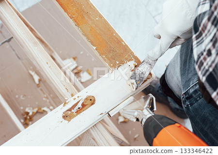 Carpenter at work, restoring an old wooden window. Carpentry. 133346422