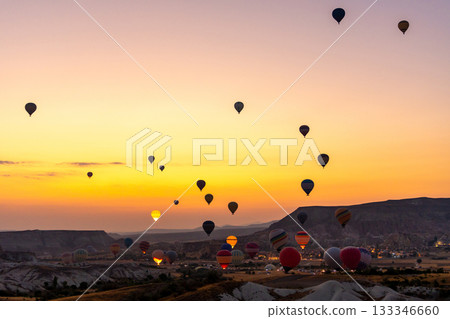 Hot air balloon flying over rocky landscape at sunrise in Cappadocia. Turkey 133346660