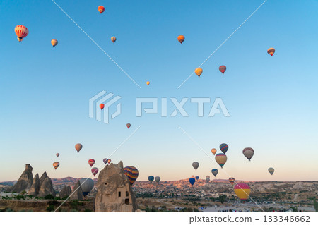 Hot air balloon flying over rocky landscape at sunrise in Cappadocia. Turkey Hot air balloon flying over rocky landscape at sunrise in Cappadocia. Turkey 133346662