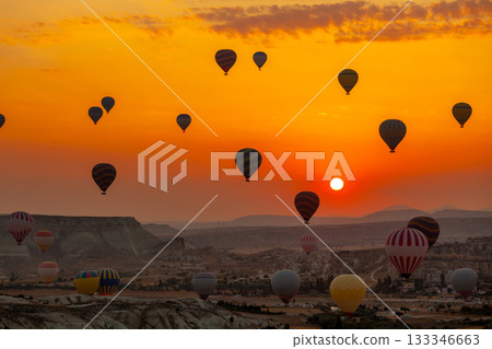 Hot air balloon flying over rocky landscape at sunrise in Cappadocia. Turkey 133346663