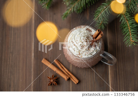 Hot chocolate with wipped cream in a cup on a dark wooden background with spices Hot chocolate with wipped cream in a cup on a dark wooden background with spices 133346756