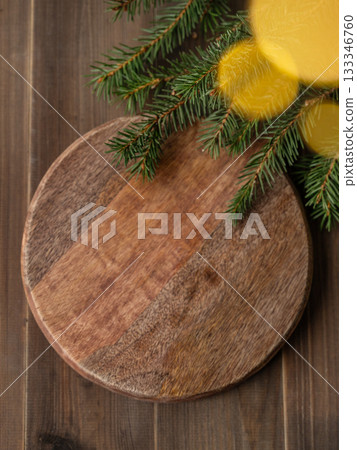 Fir branches and Christmas lights with a bokeh effect on a dark wooden background Fir branches and Christmas lights with a bokeh effect on a dark wooden background 133346760