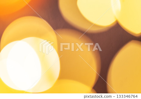 Yellow lights with a bokeh effect on a dark background. 133346764