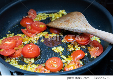 Healthy tomatoes and onion frying on stove Healthy tomatoes and onion frying on stove 133346780