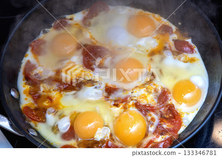 Fresh eggs frying with tomatoes. Fresh eggs frying with tomatoes. 133346781