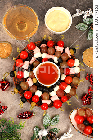 Christmas and New Year's dishes, a selection of appetizers and treats for the festive table.A tray of tartlets with pate, cheese, and olives on a concrete table,a Christmas Eve concept Christmas and New Year's dishes, a selection of appetizers and treats for the festive table.A tray of tartlets with pate, cheese, and olives on a concrete table,a Christmas Eve concept 133347153