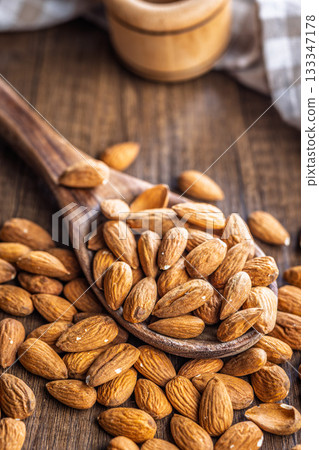 Almond kernel nuts on spoon on wooden table. Almond kernel nuts on spoon on wooden table. 133347178