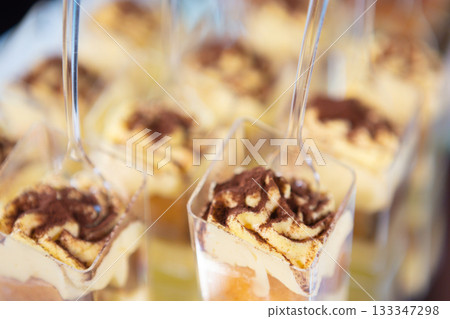 Delicious Layered Desserts in Clear Cups Displayed at a Festive Celebration Event Delicious Layered Desserts in Clear Cups Displayed at a Festive Celebration Event 133347298