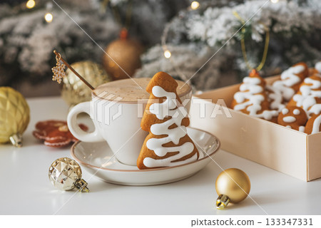 Cup of Hot Coffee with Christmas Gingerbread tree-shaped Cookies and Ornaments in Festive Setting 133347331