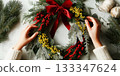 Rustic Christmas wreath flat lay. Hands holding fir branches, red berries , cotton. Making wreath at workshop 133347624