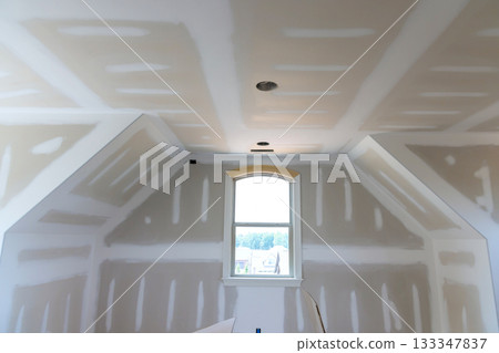 Newly renovated room bare drywall waiting for finishing touches, with space during painter 133347837