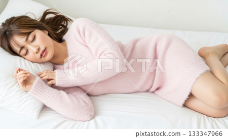 A woman in a pink knitted sweater lying in bed, sleeping peacefully with her eyes closed A woman in a pink knitted sweater lying in bed, sleeping peacefully with her eyes closed 133347966