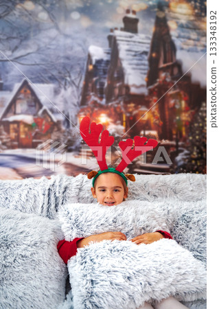 Child wearing reindeer antlers enjoying cozy Christmas holidays Child wearing reindeer antlers enjoying cozy Christmas holidays 133348192