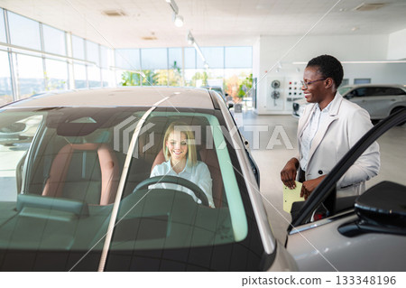 Woman buying new car with saleswoman at dealership Woman buying new car with saleswoman at dealership 133348196