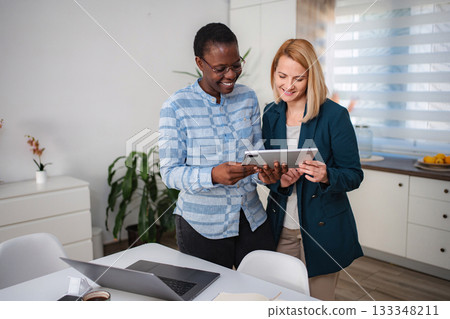 Two businesswomen collaborating on digital tablet in modern office 133348211