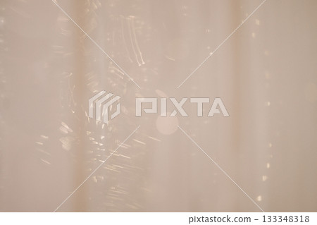 Soft beige holiday background with silver garland and ornaments Soft beige holiday background with silver garland and ornaments 133348318
