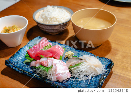A home-style dinner of tuna, horse mackerel, and squid sashimi with miso soup and rice A home-style dinner of tuna, horse mackerel, and squid sashimi with miso soup and rice 133348548