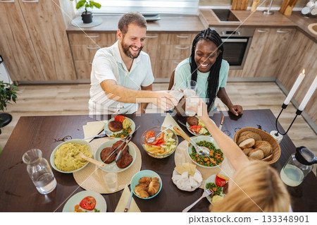 Joyful dinner gathering with friends in a cozy kitchen Joyful dinner gathering with friends in a cozy kitchen 133348901