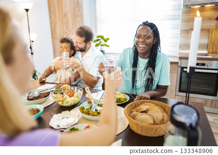Family laughs together at a cozy dining table Family laughs together at a cozy dining table 133348906