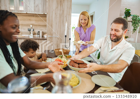 Family enjoys a meal at a cozy kitchen table 133348910