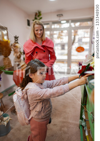 Little girl explores a shop filled with colorful flowers and decorations on a sunny afternoon 133348930