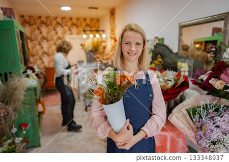 Cheerful florist showcasing vibrant flowers in a charming shop full of creativity Cheerful florist showcasing vibrant flowers in a charming shop full of creativity 133348937