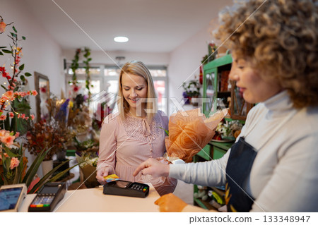 Buying a beautiful bouquet at a vibrant flower shop in the heart of the city 133348947