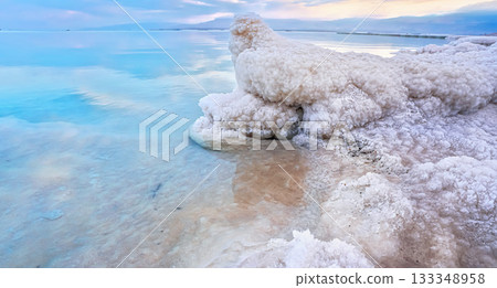 Salt crystal formations on shore of Dead Sea, calm clear water surface near, typical morning scenery at Ein Bokek beach, Israel Salt crystal formations on shore of Dead Sea, calm clear water surface near, typical morning scenery at Ein Bokek beach, Israel 133348958