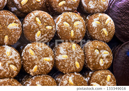 A closeup of stacked handmade german gingerbreads with almonds at a christmas market stall, showing texture, tradition, and holiday craftsmanship A closeup of stacked handmade german gingerbreads with almonds at a christmas market stall, showing texture, tradition, and holiday craftsmanship 133349016