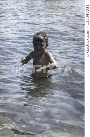 Vintage portrait of a five-year-old boy playing in the sea. USSR. Retro photo from 1965. 133349031