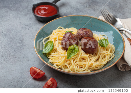 Delicious spaghetti with meatballs on plate, tomato sauce and basil on gray background top view 133349190