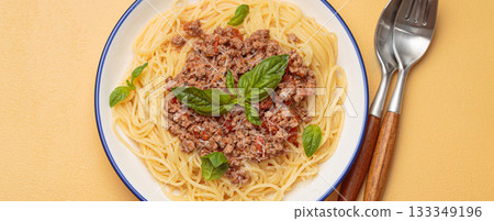 Spaghetti bolognese with basil and parmesan on warm beige background, Italian cuisine Spaghetti bolognese with basil and parmesan on warm beige background, Italian cuisine 133349196