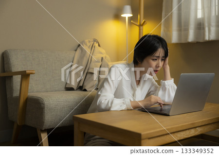 看一台計算機的少婦在客廳在晚上 133349352