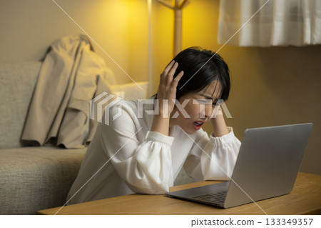 看一台計算機的少婦在客廳在晚上 133349357