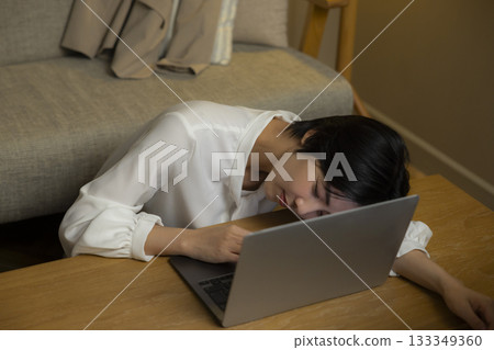 看一台計算機的少婦在客廳在晚上 看一台計算機的少婦在客廳在晚上 133349360