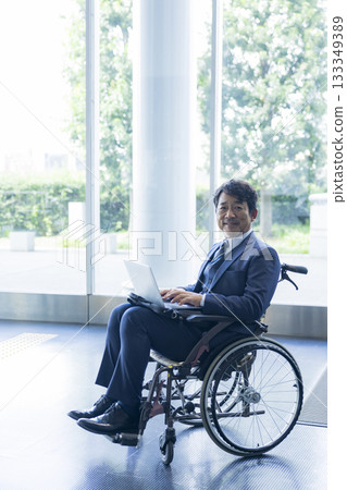 A man in a suit sitting in a wheelchair A man in a suit sitting in a wheelchair 133349389
