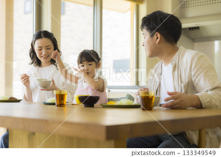 一家人其樂融融地圍坐在餐桌旁 133349549